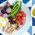 nicoise salad with tuna, eggs, green beans, potatoes, olives, and cherry tomatoes