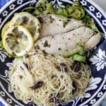 bowl with foil packet tilapia with lemons, zucchini, and pasta