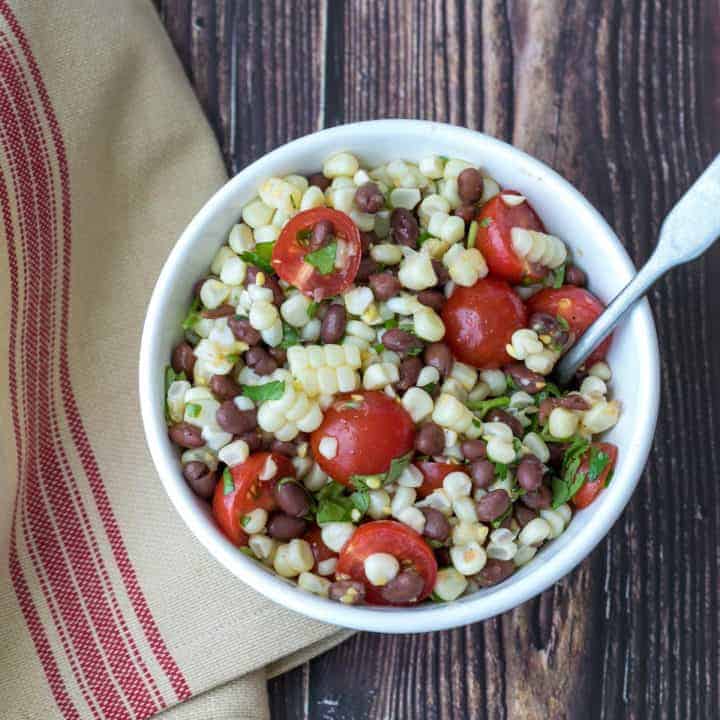 black bean and corn salad in bowl with kitchen towel