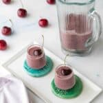 cherry chia seed smoothies in shot glasses with blender, napkin, and cherries