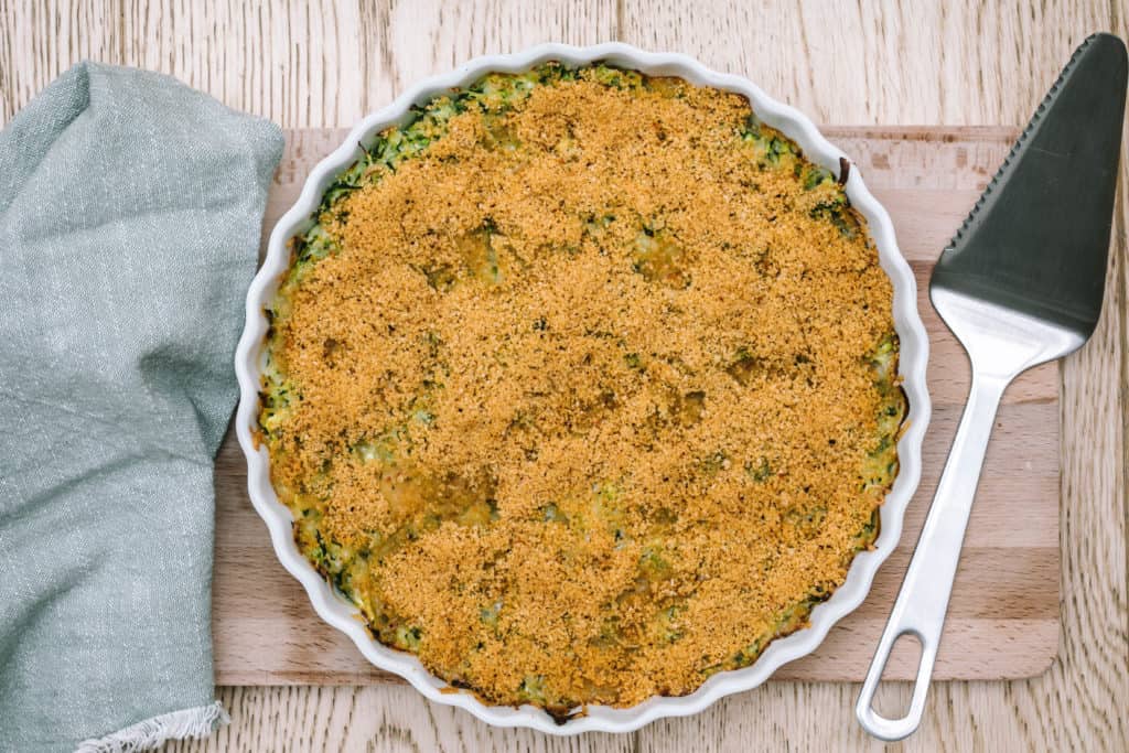 baked zucchini gratin on cutting board with green napkin and pie server