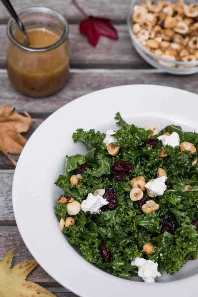 kale salad with cranberries, goat cheese, and hazelnuts with red wine vinaigrette and bowl of chopped hazelnuts