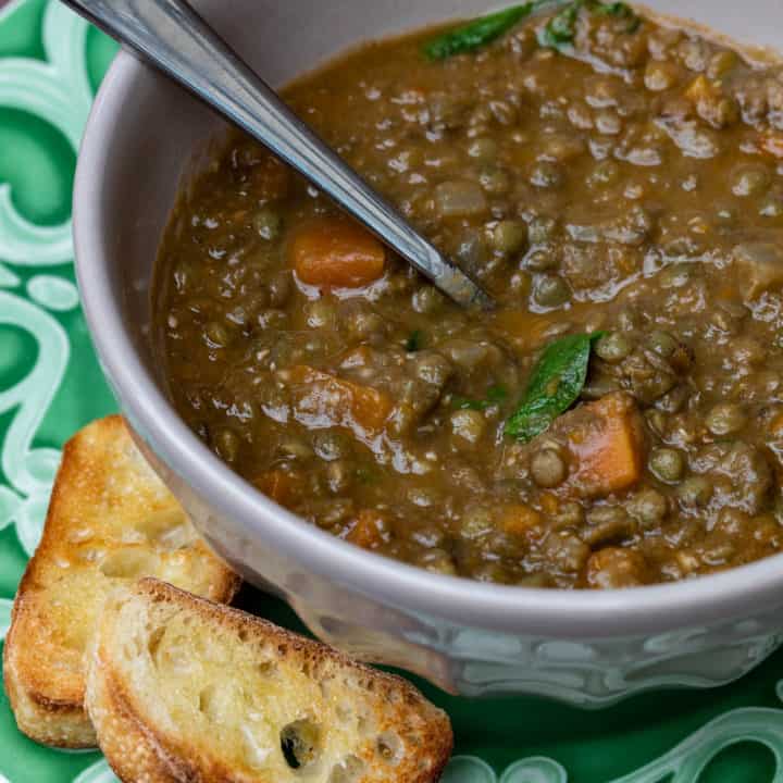 bowl of lentil soup with baguette toasts