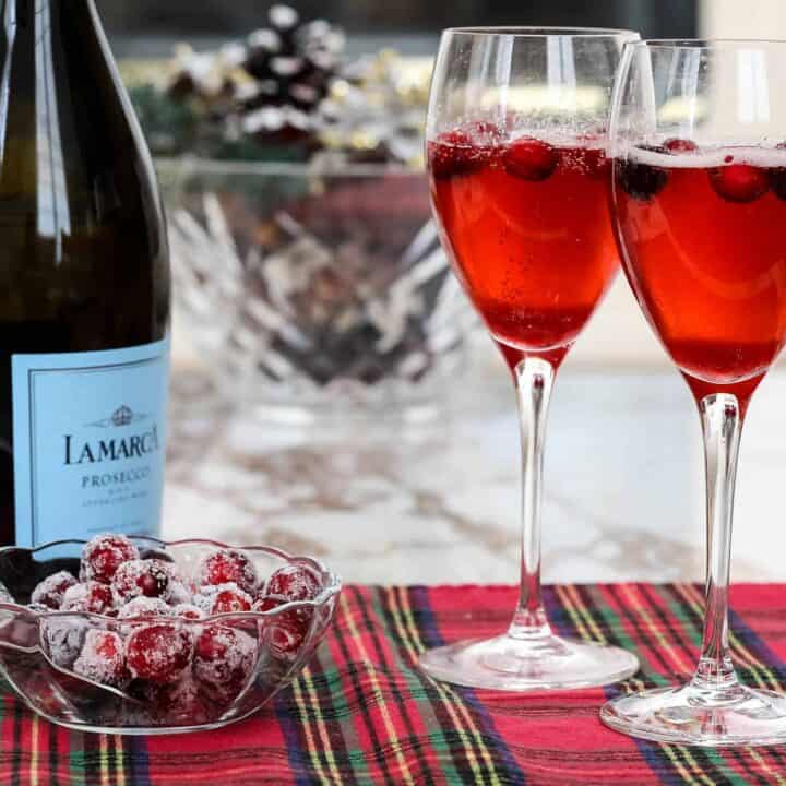 cranberry mimosas with prosecco and bowl of sugared cranberries