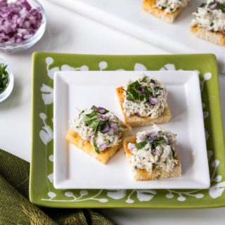 Cilantro-lime crab salad on paprika toasts on plates with toppings