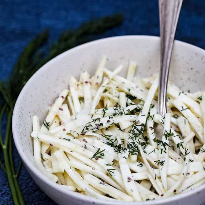 celeriac remoulade in bowl with fork and sprig of dill
