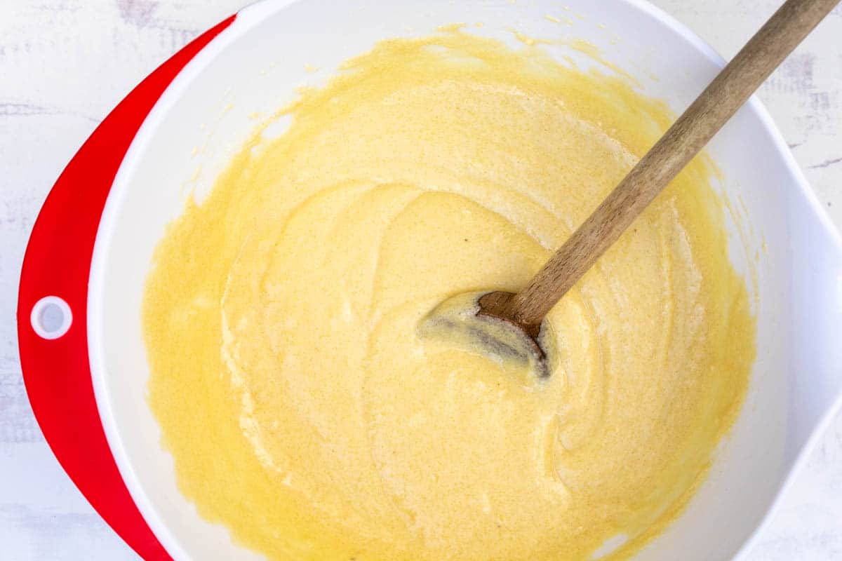 batter for lemon ricotta cake in large bowl with wooden spoon