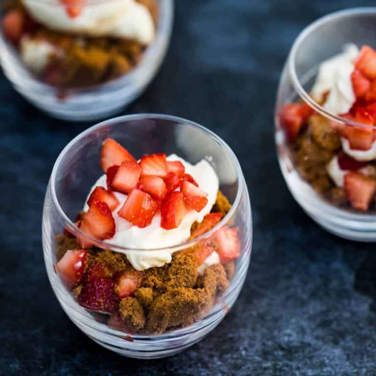 strawberry parfait with mascarpone cream in short glass with two other parfaits in the background
