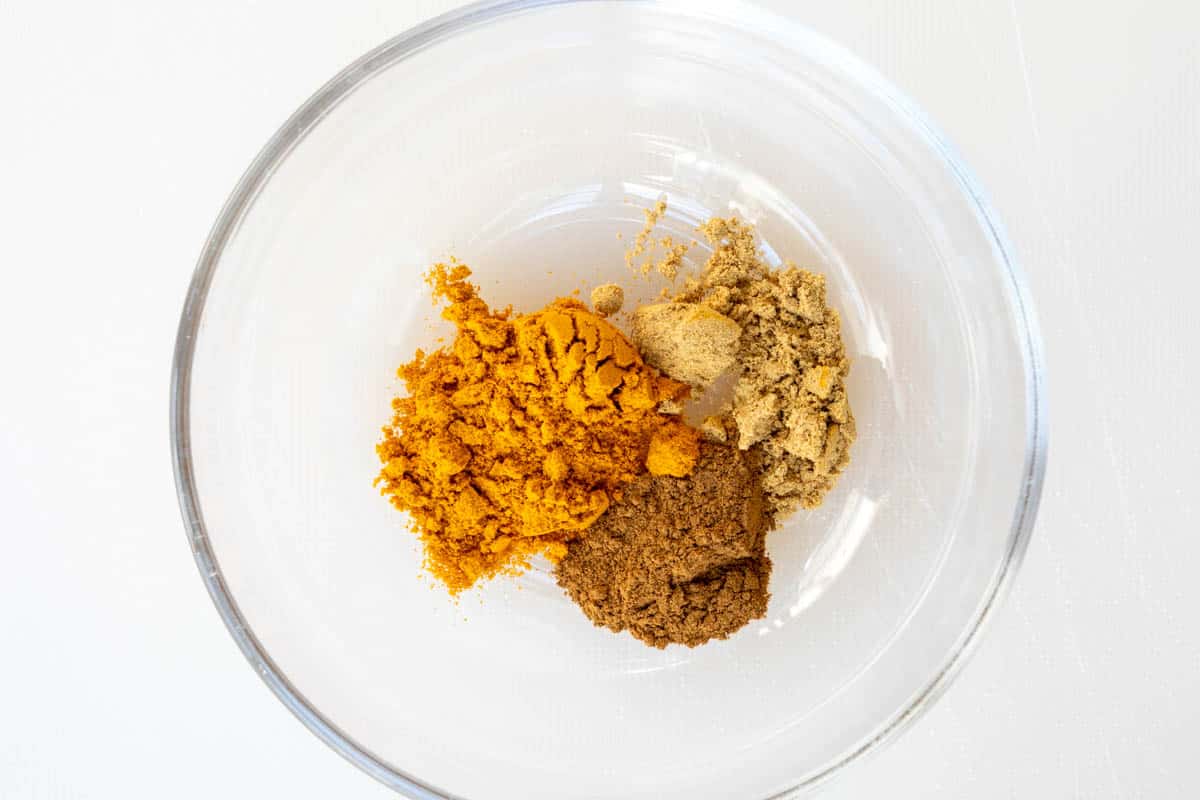 ground turmeric, ginger, and cinnamon in a small glass bowl