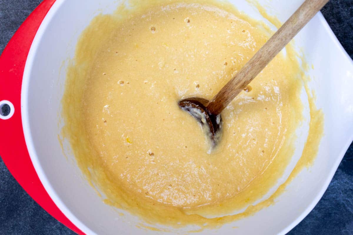 batter for lemon almond flour muffins in mixing bowl with wooden spoon