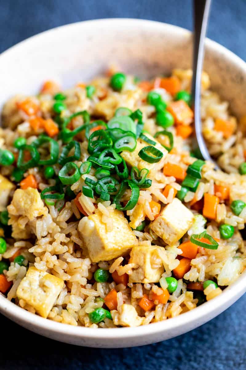 close up of tofu fried rice in bowl with fork