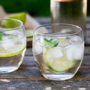 rosé spritzer with wine bottle and lime on cutting board in background
