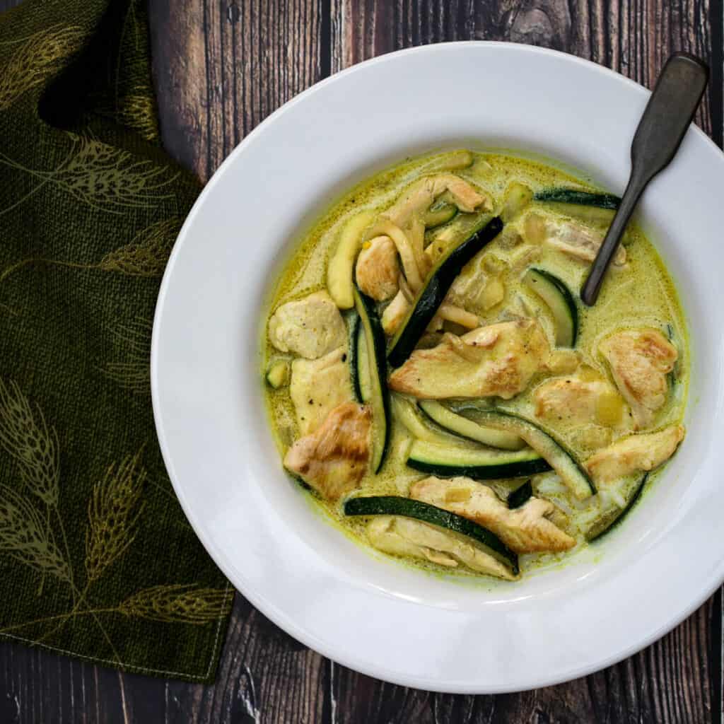 bowl of chicken curry with coconut milk and zucchini