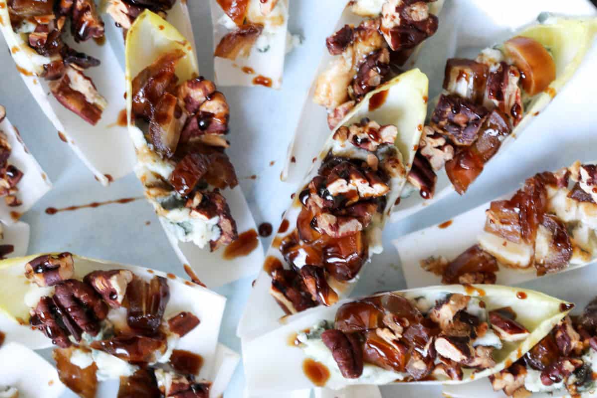 close up of blue cheese date and pecan endive appetizer with balsamic drizzle