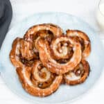 puff pastry cinnamon rolls stacked on plate
