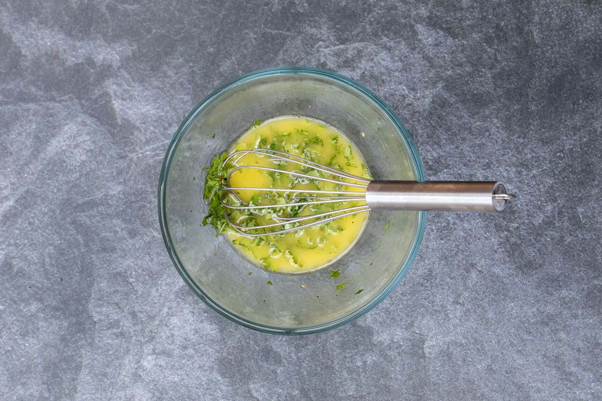glass bowl with cilantro-lime dressing and whisk