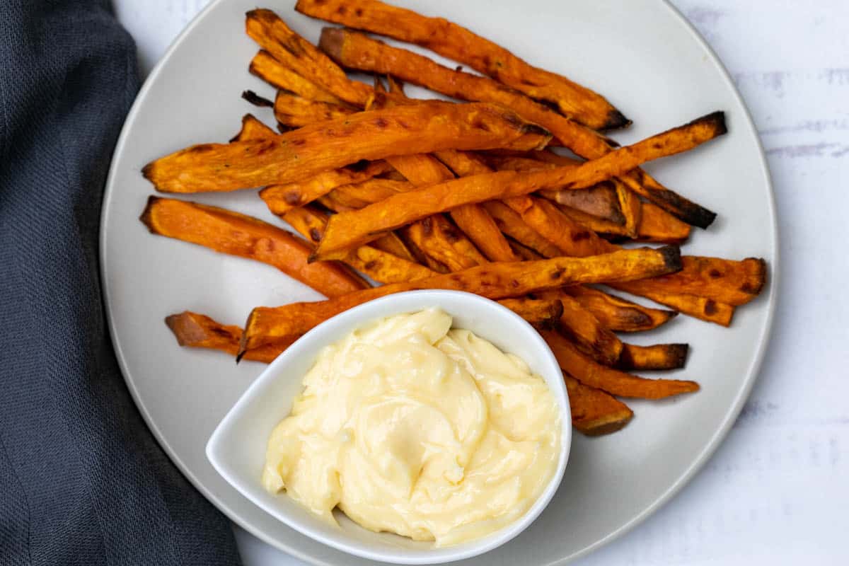 sweet potato fries with truffle aioli on plate with blue towel