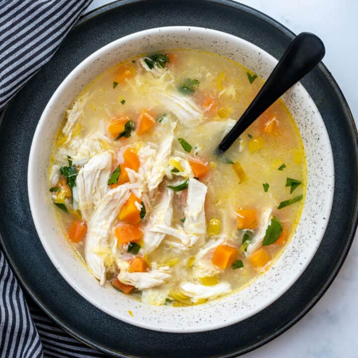bowl of chicken soup with rice with spoon and napkin