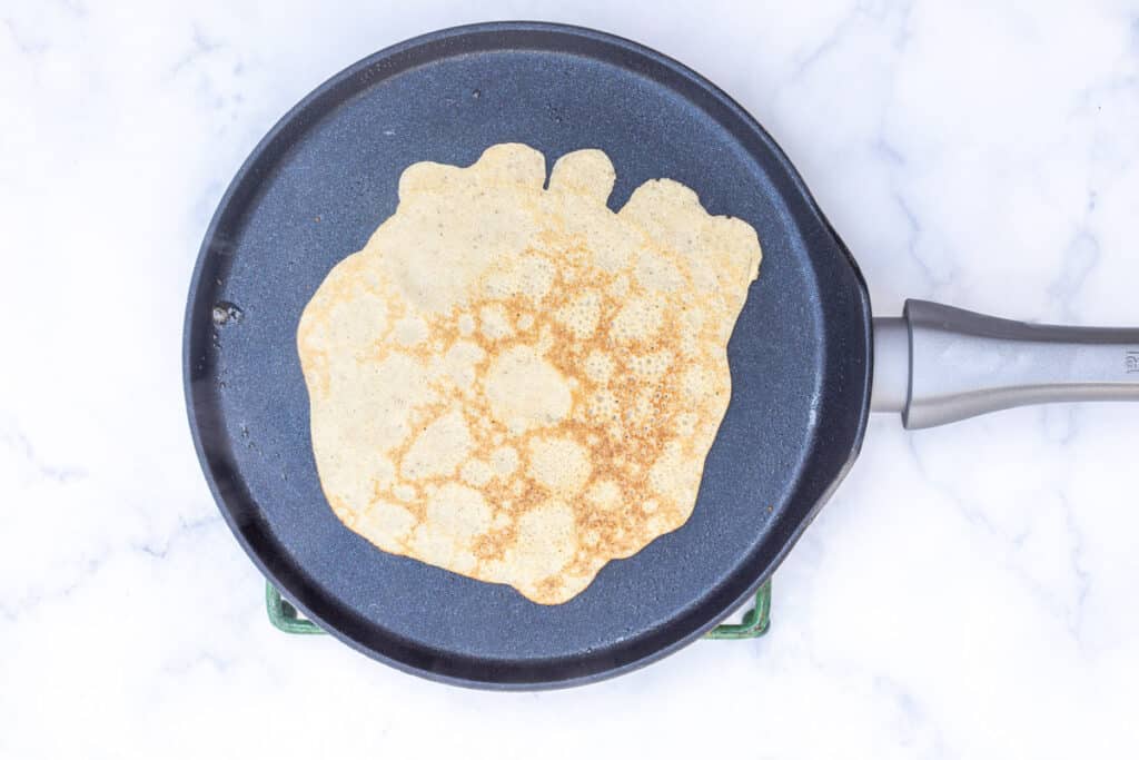 almond flour crepe in crepe pan after flipping