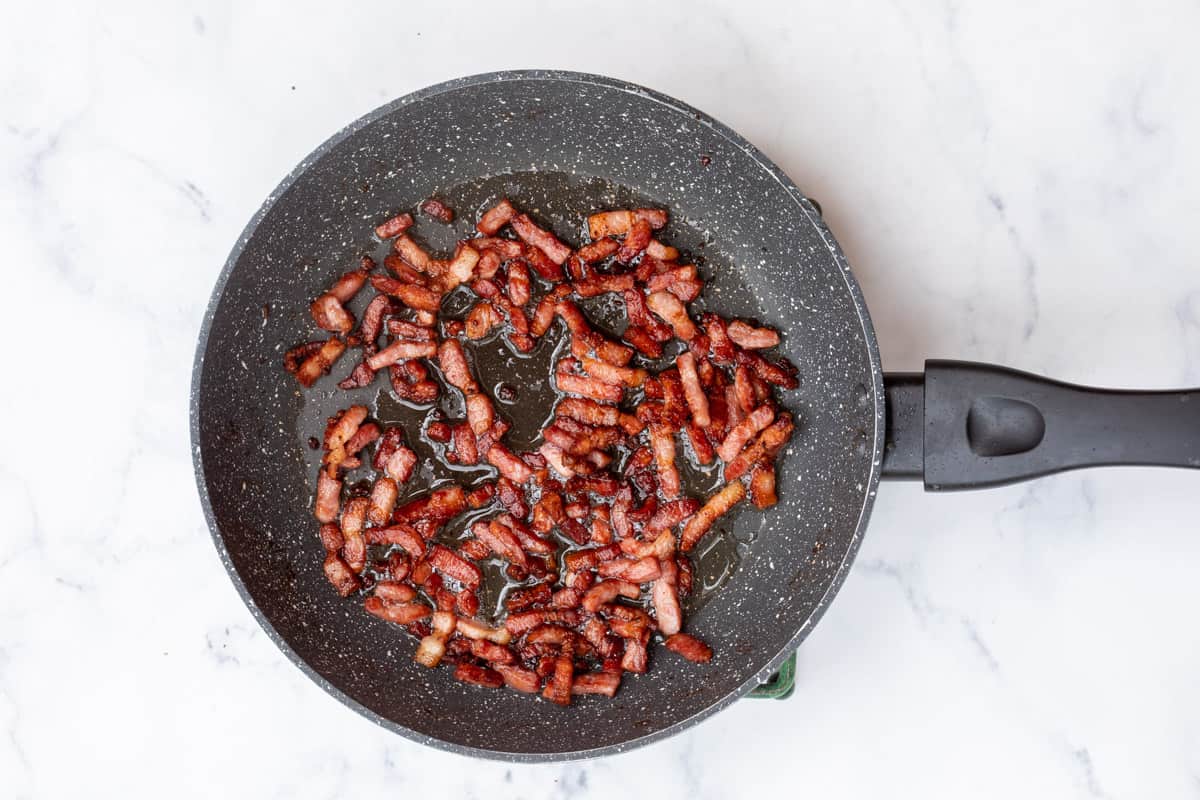 skillet with cooked lardons or bacon