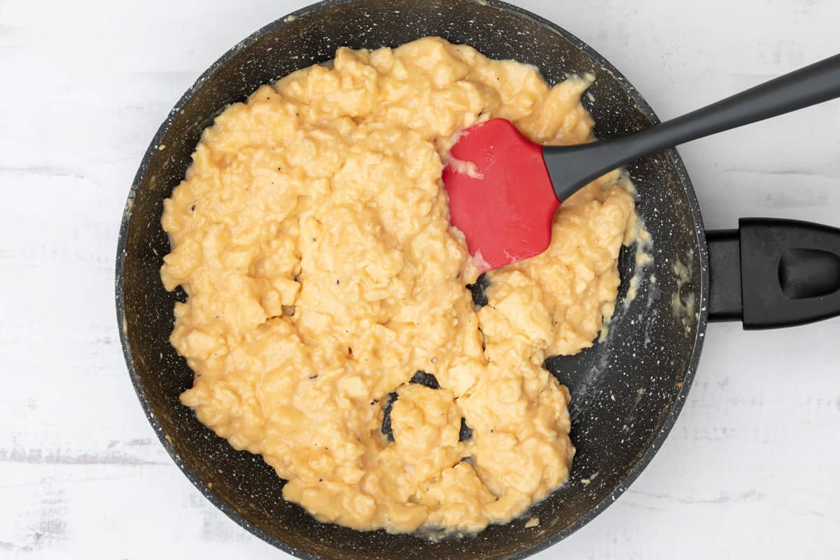 softly scrambled eggs in skillet with spatula