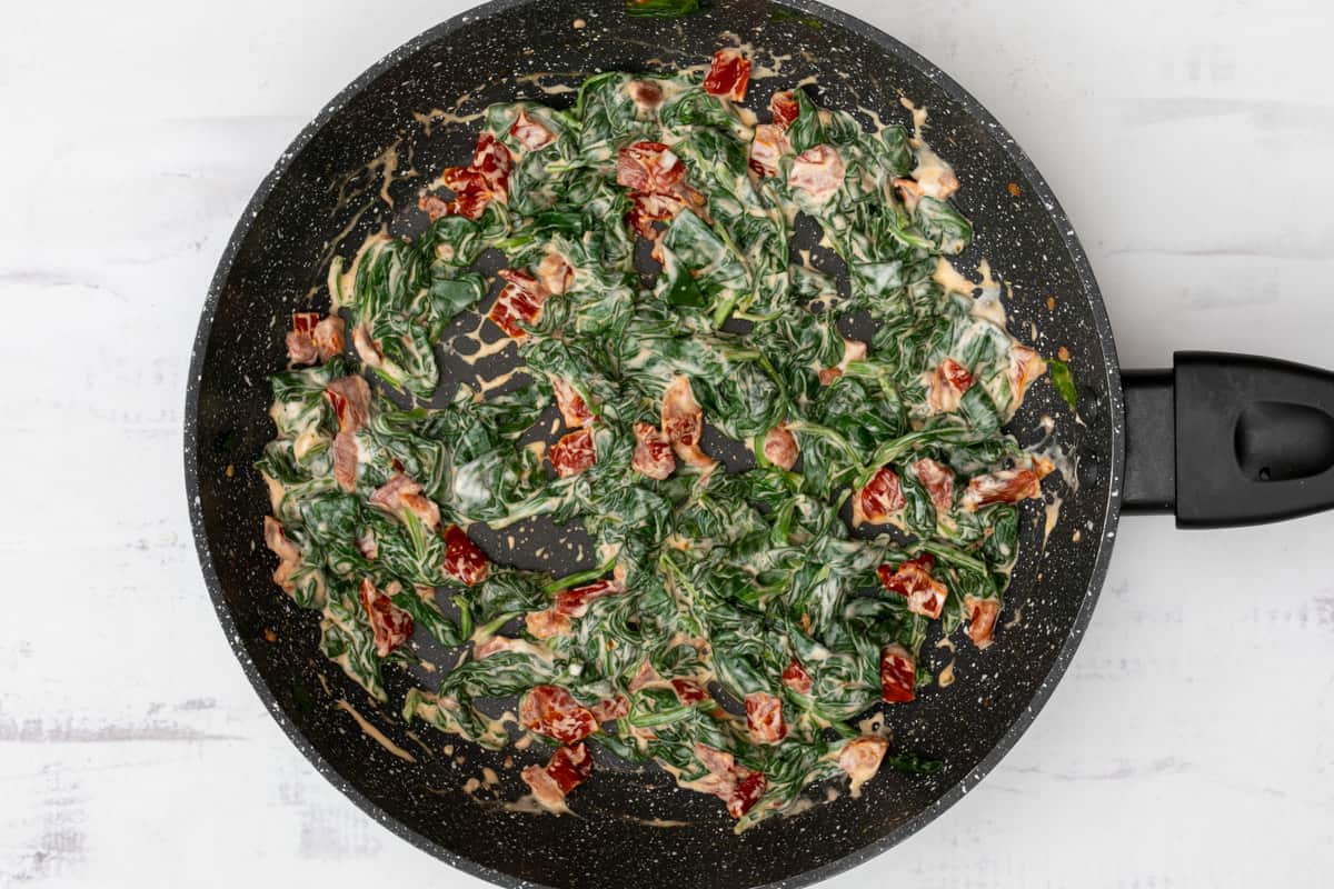 spinach, chopped sun-dried tomatoes, and cream cheese in skillet
