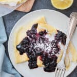 plate with two lemon blueberry crepes with fork