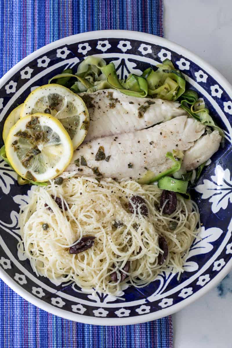 large bowl with foil packet tilapia with zucchini and angel hair pasta