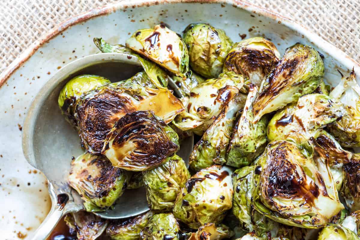close up of balsamic-glazed Brussels sprouts on serving spoon on plate