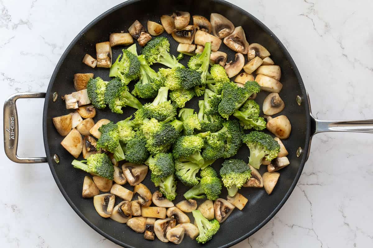 sautéed mushrooms in pan with broccoli added