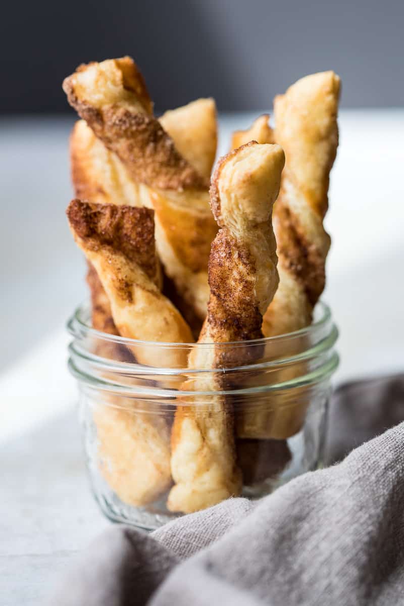 jar with puff pastry cinnamon twists standing up next to napkin