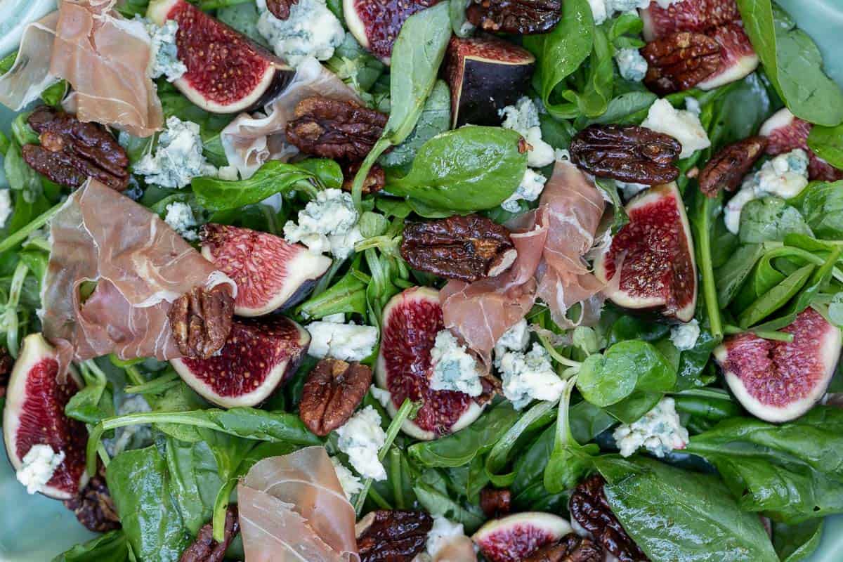 close up of fig salad with blue cheese and caramelized pecans and prosciutto