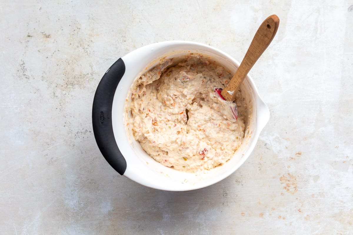 olive dip with spatula in mixing bowl