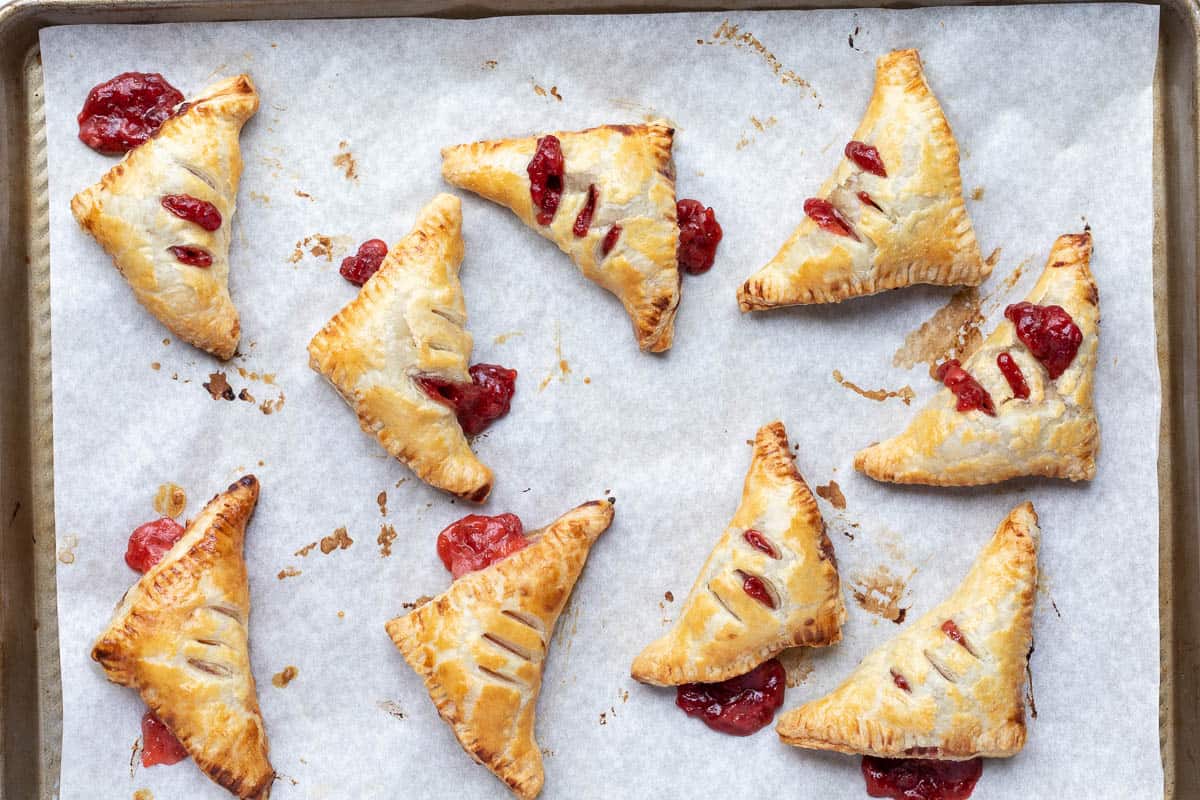 baked strawberry turnovers on parchment-lined sheet pan.