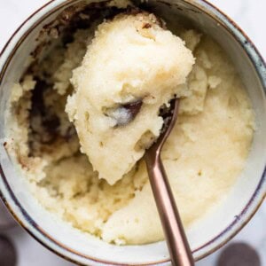 close up of top of chocolate chip mug cake with spoon holding a bite.