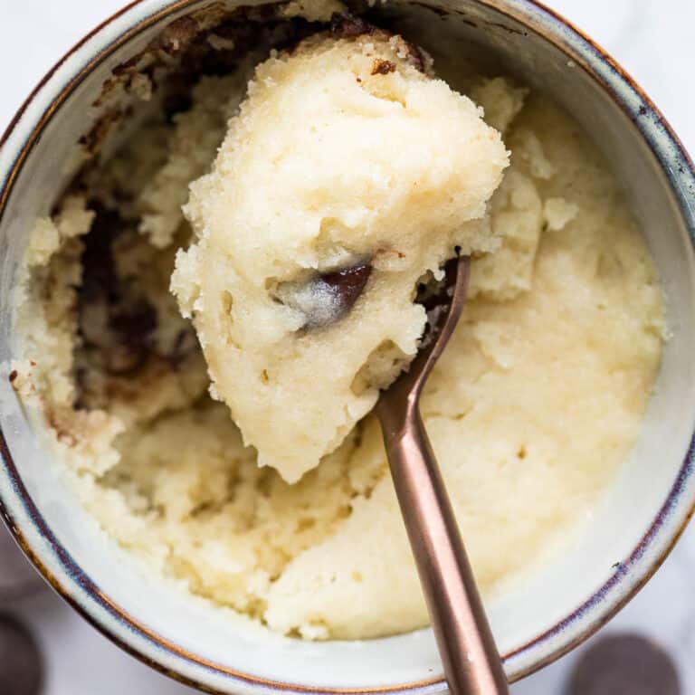 close up of top of chocolate chip mug cake with spoon holding a bite.