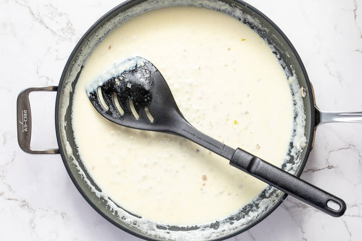 mascarpone cream sauce in skillet with spatula.