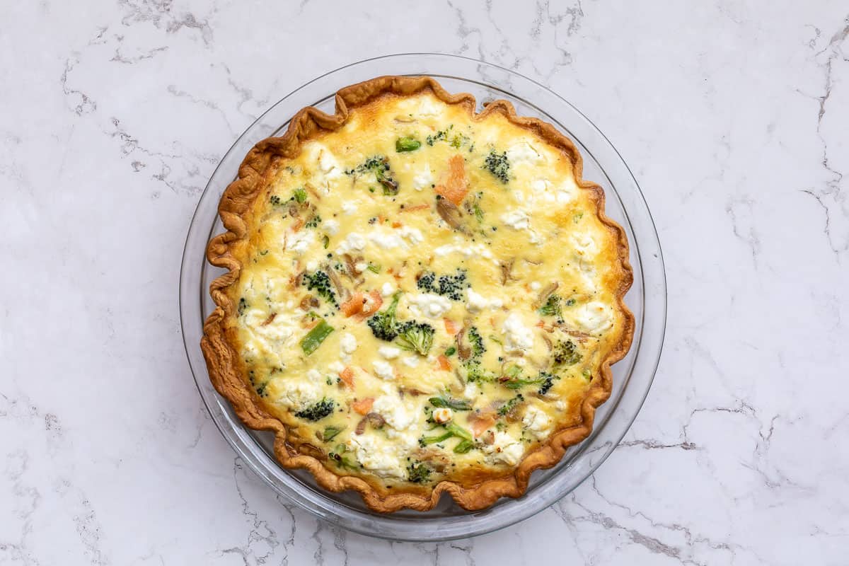 baked salmon and broccoli quiche in pie pan.