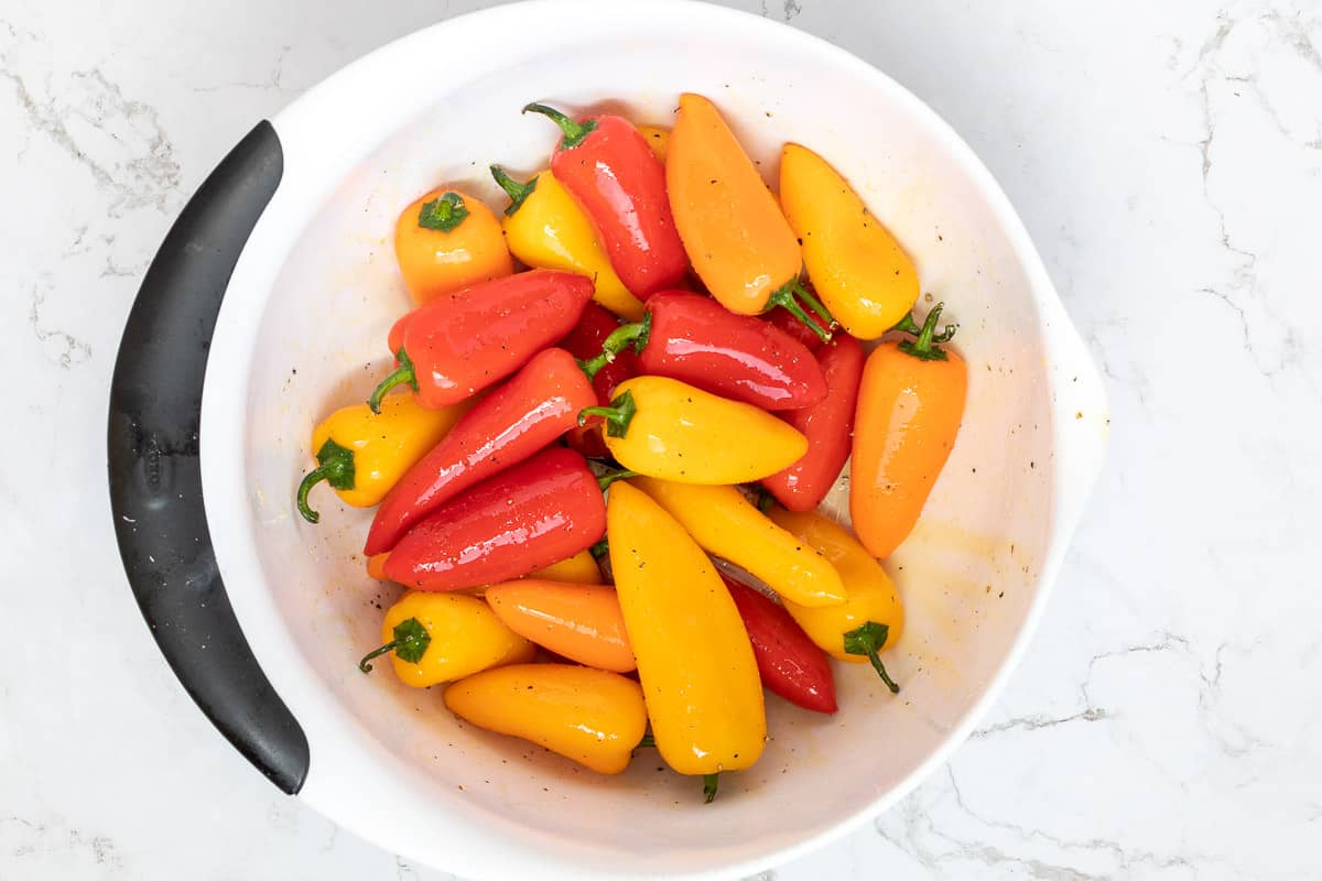 bowl of mini peppers tossed with olive oil, salt, and pepper.