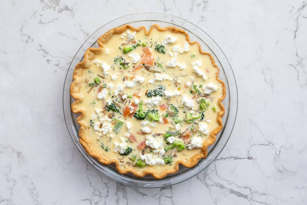 unbaked broccoli and salmon quiche in pie pan.