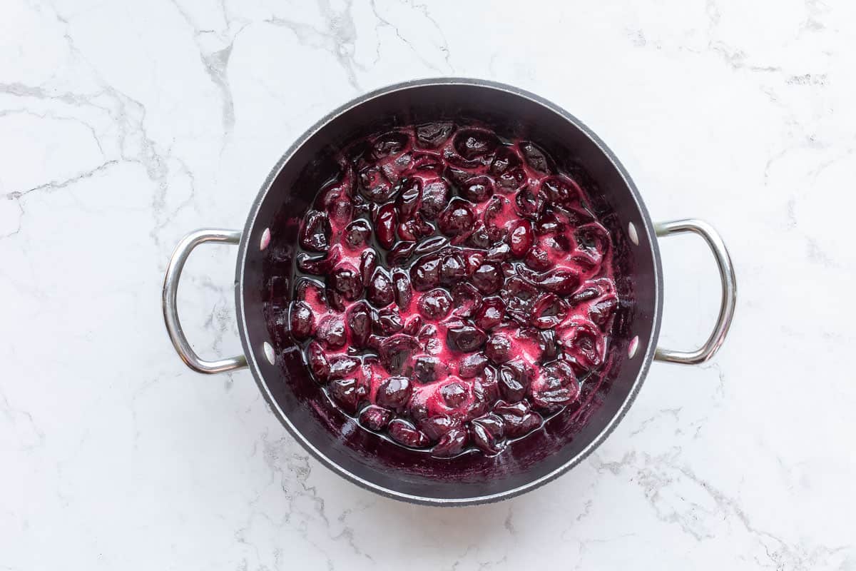 cooked cherry compote in saucepan.