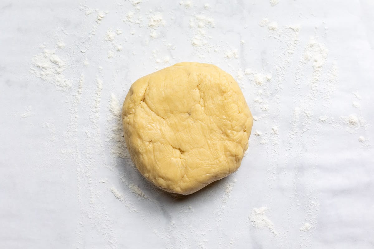 disk of pâte sucrée dough on a floured sheet of parchment paper.