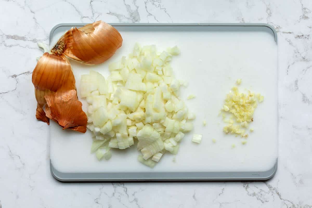 chopped onion and minced garlic on cutting board.