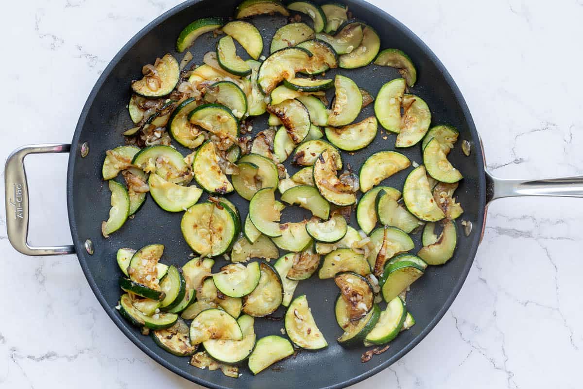 sauteed shallots and zucchini slices in large skillet.