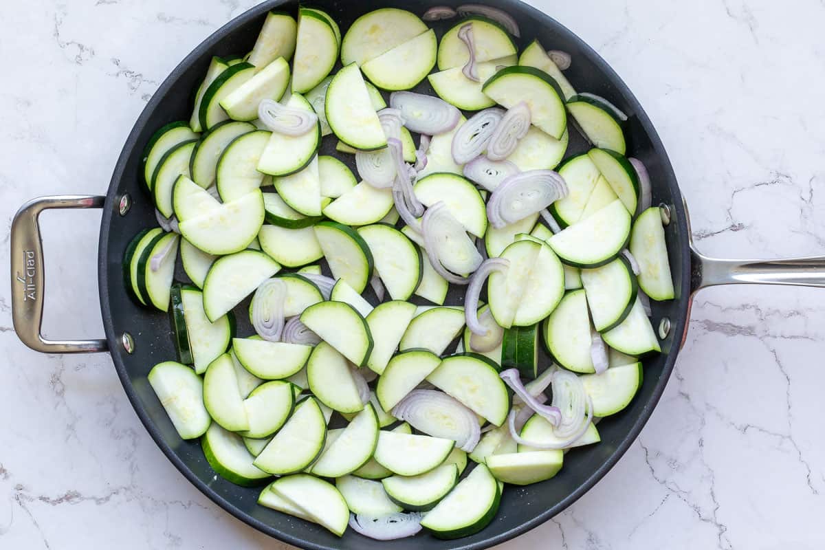 raw zucchini slices and sliced shallots in large skillet.