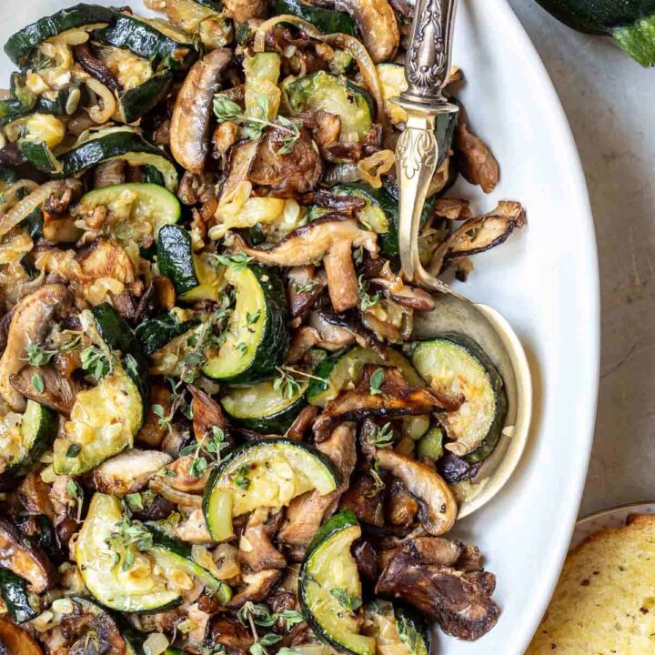 sauteed mushrooms and zucchini with fresh thyme on platter.