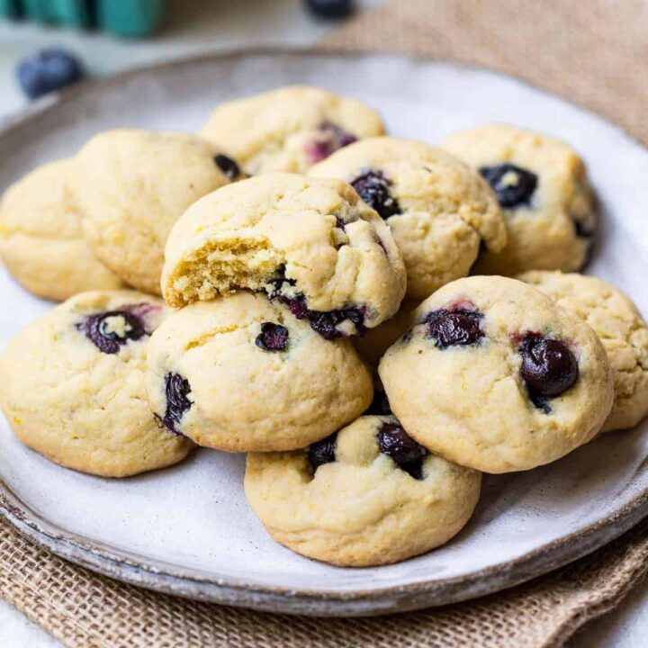 plate of lemon blueberry cookies with top cookie with a bite out of it.