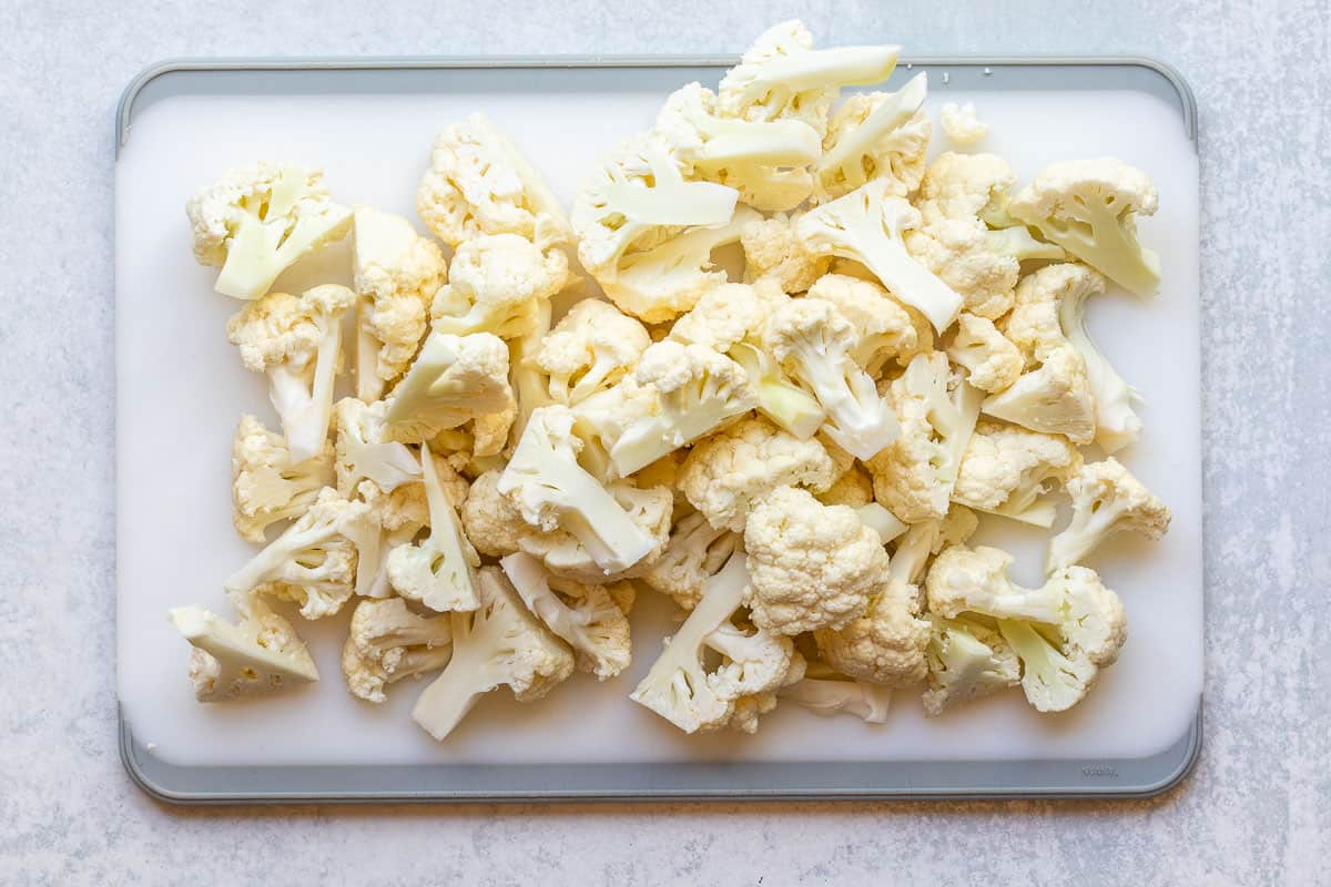 chopped cauliflower florets on cutting board.