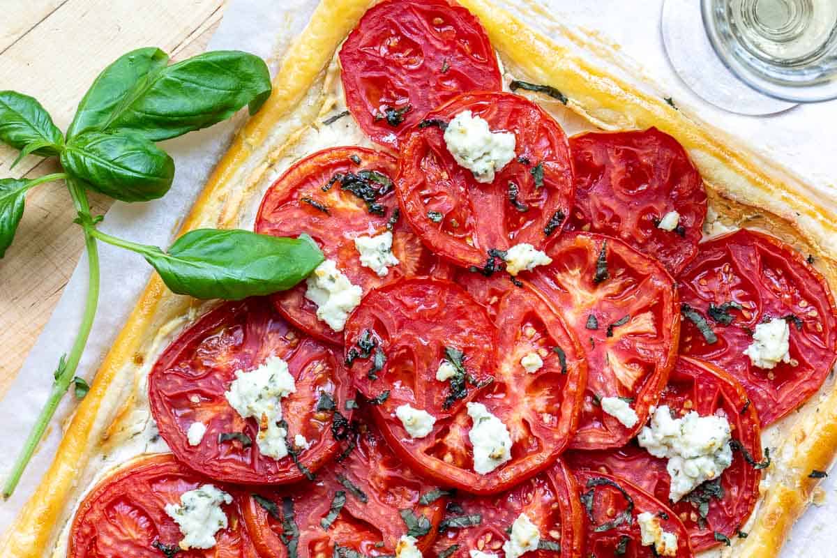 puff pastry tomato tart with basil sprig.