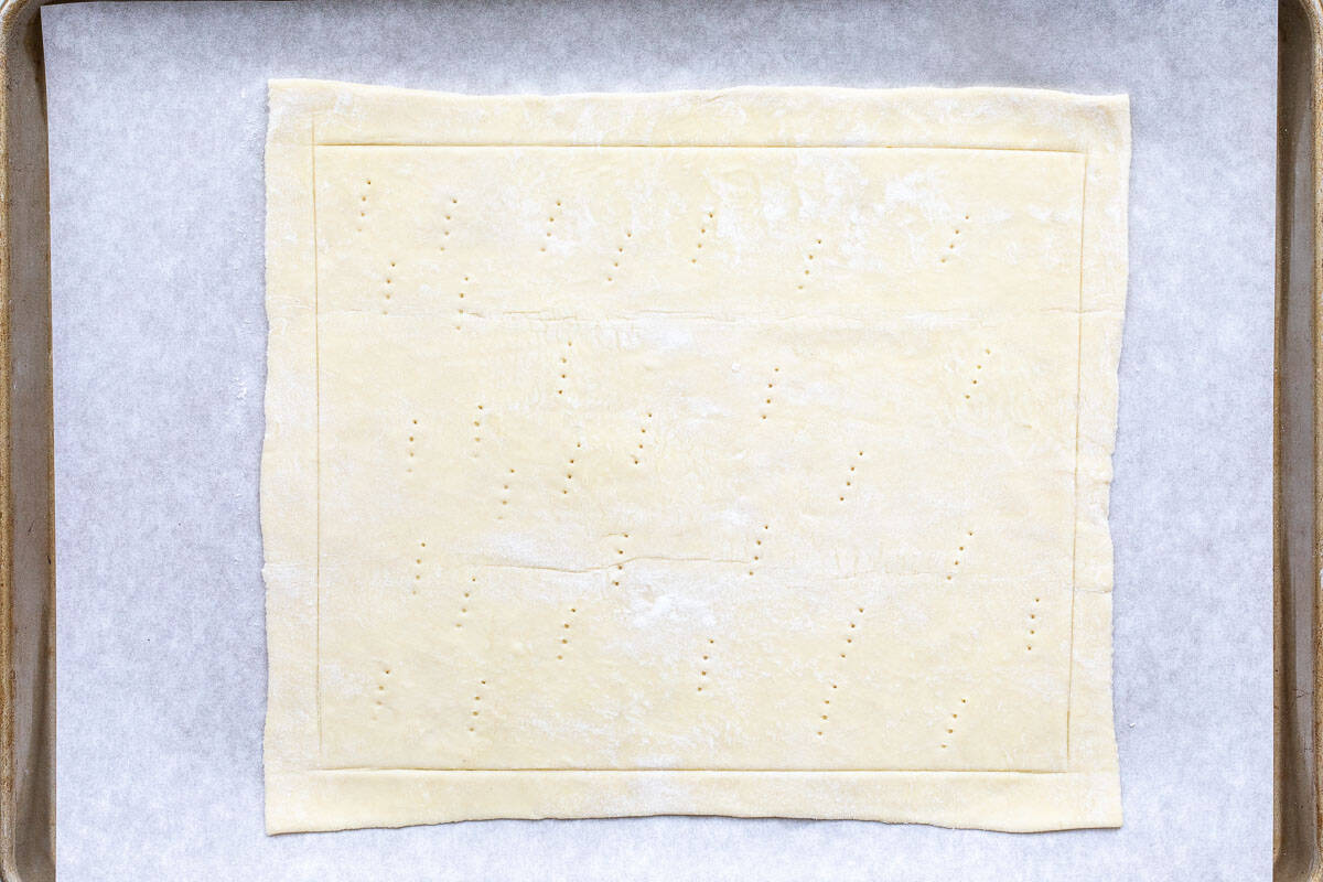 puff pastry dough with border marked and pricked with fork in the middle.